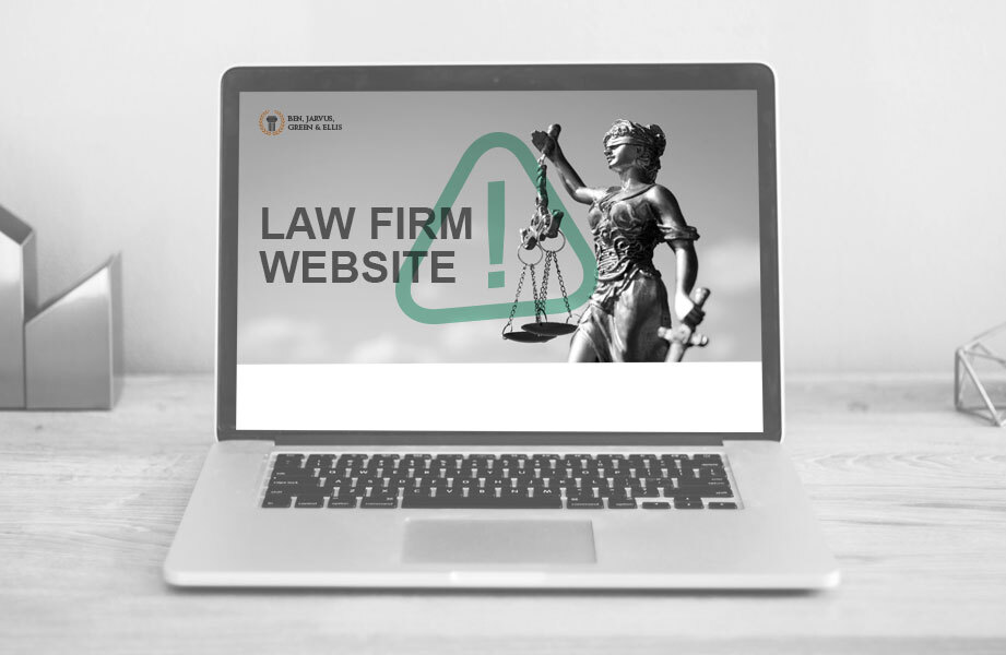 Laptop on wooden desk displaying law firm website with Lady Justice statue and text.