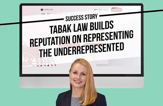 Professional woman smiling in front of computer displaying Tabak Law website.