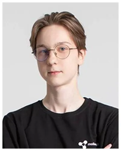 Portrait of a young person with glasses wearing a black shirt against a neutral background.
