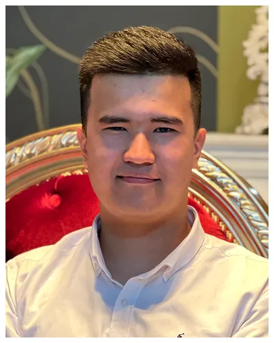 Portrait of a young man with short dark hair, wearing a white shirt, seated on an ornate red and gold chair.