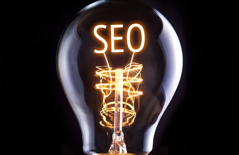 Lightbulb on Black Background with SEO Spelled by Filament