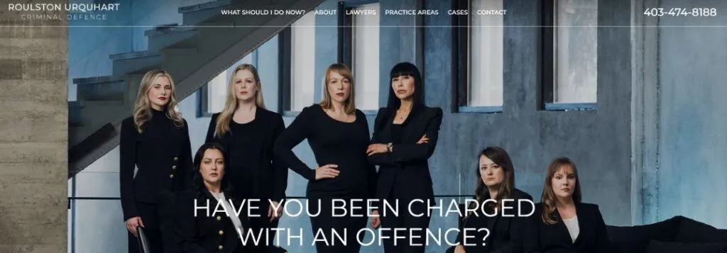 Women in Black Sitting and Standing on Website of Roulston Urquhart Criminal Defence