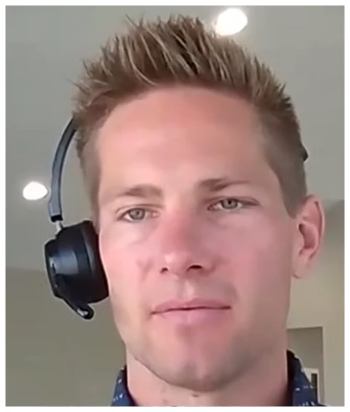 Close-up of a young man with spiked blond hair wearing a black headset microphone indoors.