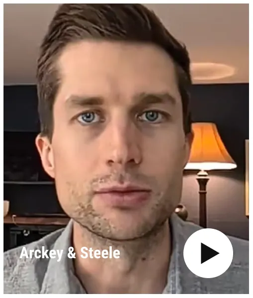 Close-up portrait of a man with blue eyes in a room with a lamp and dark walls.